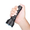 Hand holding black Olight tactical flashlight