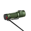 Green Olight Baton 3 Pro Max Turbo flashlight charging via magnetic cable, white background.