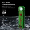 IPX5 water resistant green flashlight with red splatters glowing in splashing water, showing reliable rainproof use.