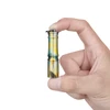 Hand holding Olight i3E EOS mini keychain flashlight with tropical palm pattern on white background