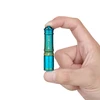 Hand holding tiny Olight i3E EOS blue and gold keychain flashlight, showing compact EDC size.