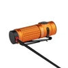 Olight Orange Baton 4 Premium Edition charging on white background, showcasing its compact design and powerful illumination.
