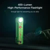Green 400 lumen high performance flashlight with red splatter design standing upright and turned on in the dark