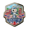 Olight UK 8th anniversary medal with mascot, double-decker bus, phone booth, Stonehenge, and Union Jack.