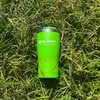 Green Olight insulated stainless steel travel tumbler on lush green grass