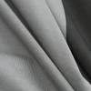 Folded grey cotton jersey fabric texture close-up. Soft natural textile, draped for comfortable garments.