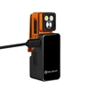 Olight orange clip-on flashlight charging in a black magnetic charging dock on a white background