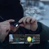 Olight Black Perun 3 Mini Headlamp being detached by hand showing quick-release mechanism for hands-free outdoor use