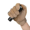 Hand in tan tactical glove holding black flashlight