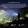 Olight Seeker Ultra Black Flashlight casting 4800 lumens bright white beam illuminating dark forest hillside at night