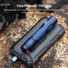 Blue Olight magnetic charging tactical flashlight lying on a rugged black power bank outdoors